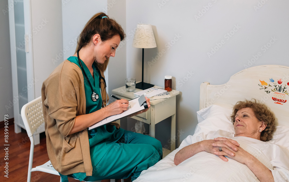Female doctor filling out a questionnaire to a senior patient Female doctor filling out a questionnaire to a senior patient