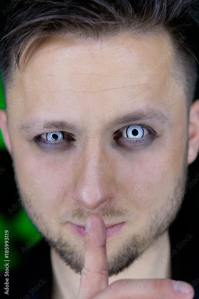 Obraz premium man holding finger near mouth in silence gesture manner