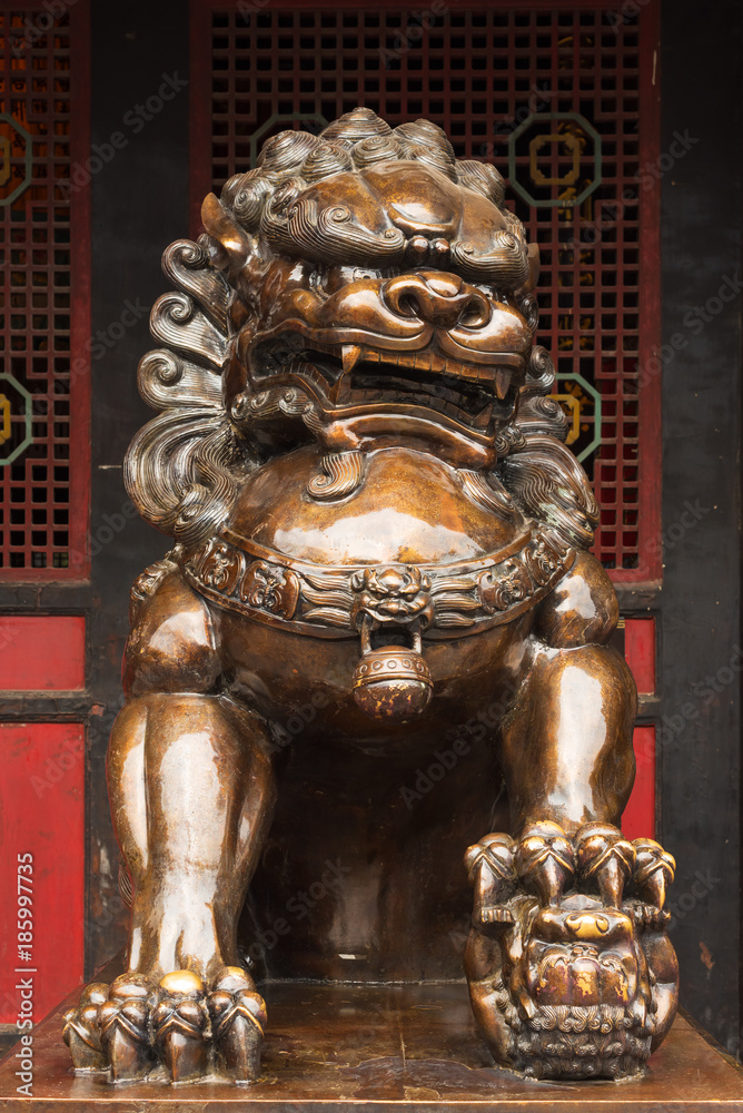 Obraz premium Lion bronze statue in front of a buddhist temple in China