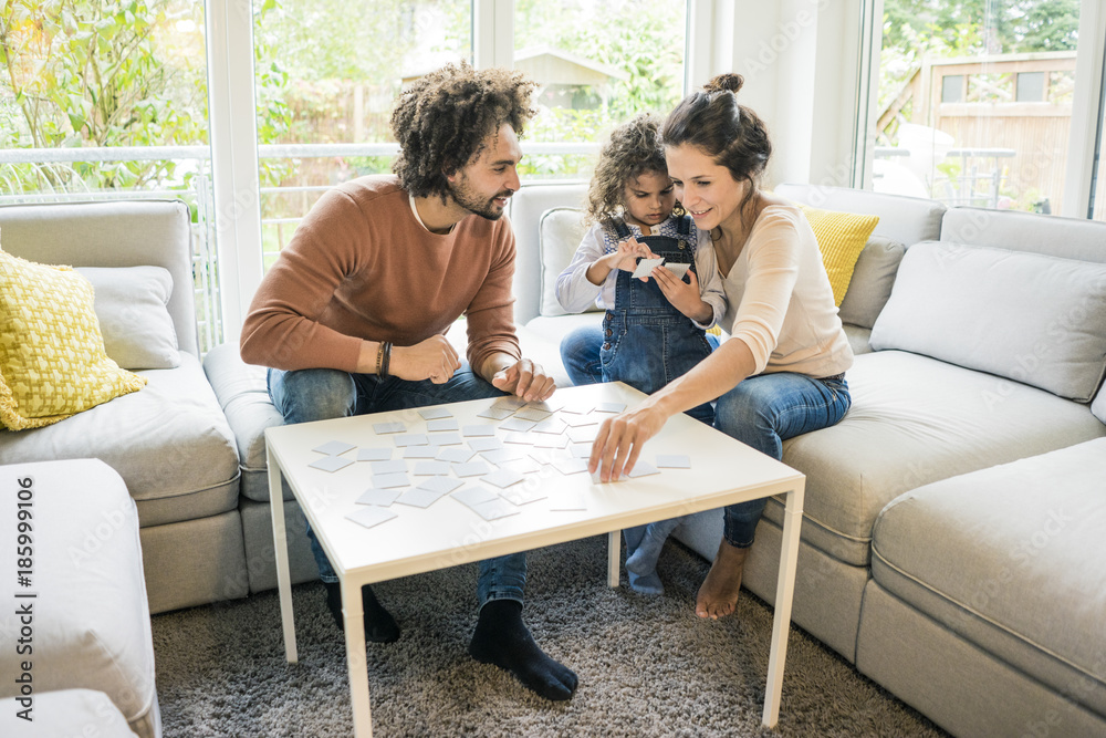 Family sitting on couch , playing memory game Family sitting on couch , playing memory game