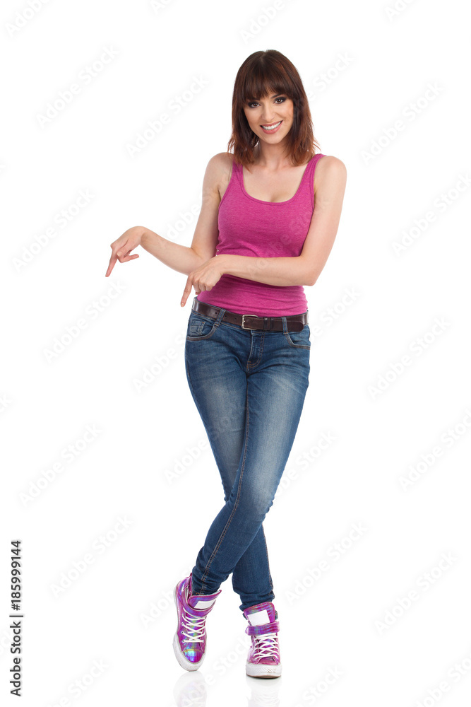 Smiling Young Woman Is Standing And Pointing Down Smiling Young Woman Is Standing And Pointing Down