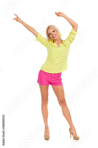 Blond Woman In High Heels Is Standing And Waving Hands