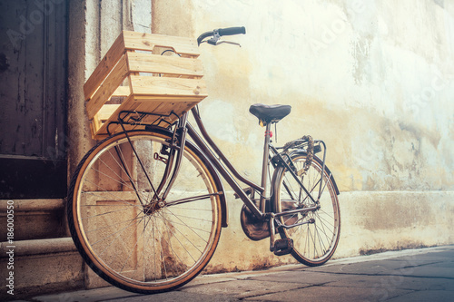 vintage bicycle with copy space, bike with wooden basket standing on a wall © missizio01