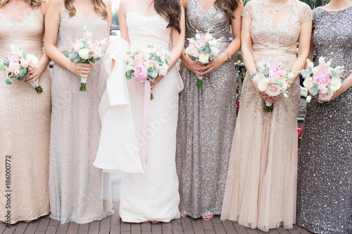 bride and bridesmaids holding pastel bouquets photo