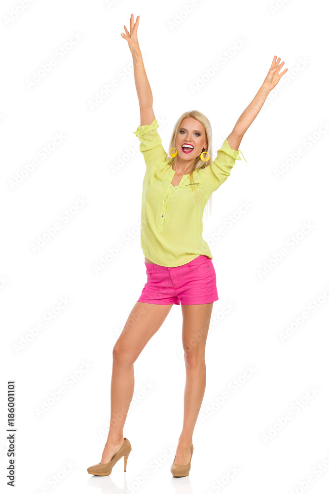 Blond Woman In High Heels Is Standing With Arms Raised And Shouting. Blond Woman In High Heels Is Standing With Arms Raised And Shouting.