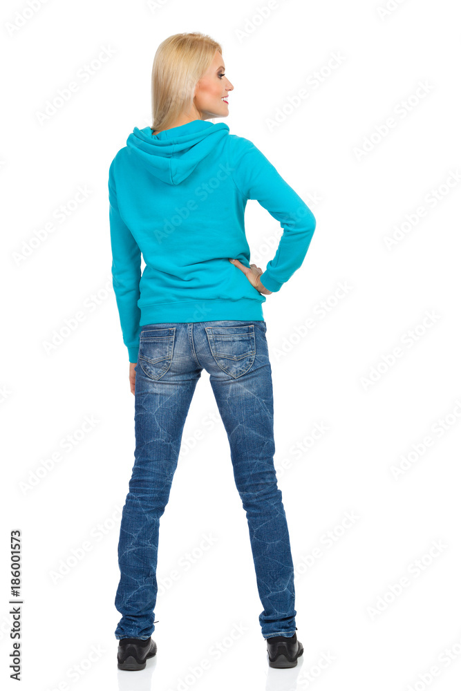 Fototapeta premium Woman In Turquoise Hoodie Is Standing And Looking Away. Rear View.