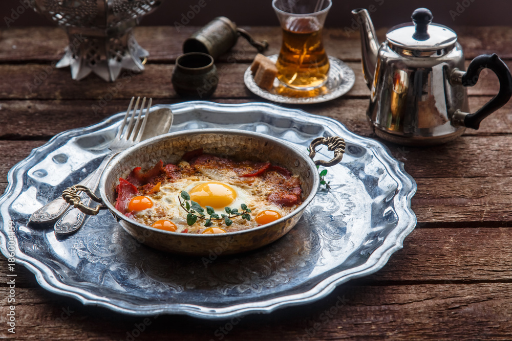Copper pan with fried eggs and sausages, turkish style Copper pan with fried eggs and sausages, turkish style