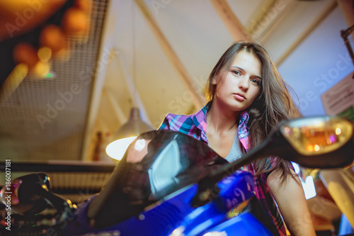 High angle view of sensual young brunette woman posing on motorcycle photo