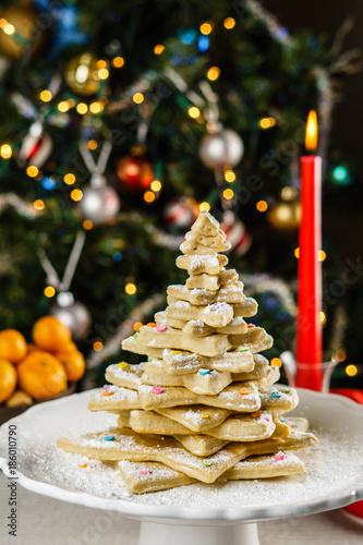 freshly baked christmas tree shape cookies on a table with blurred background.