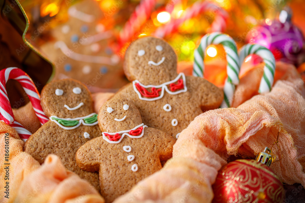 Three ginger Christmas cookies on the background of the included garland in the festive atmosphere of the new year