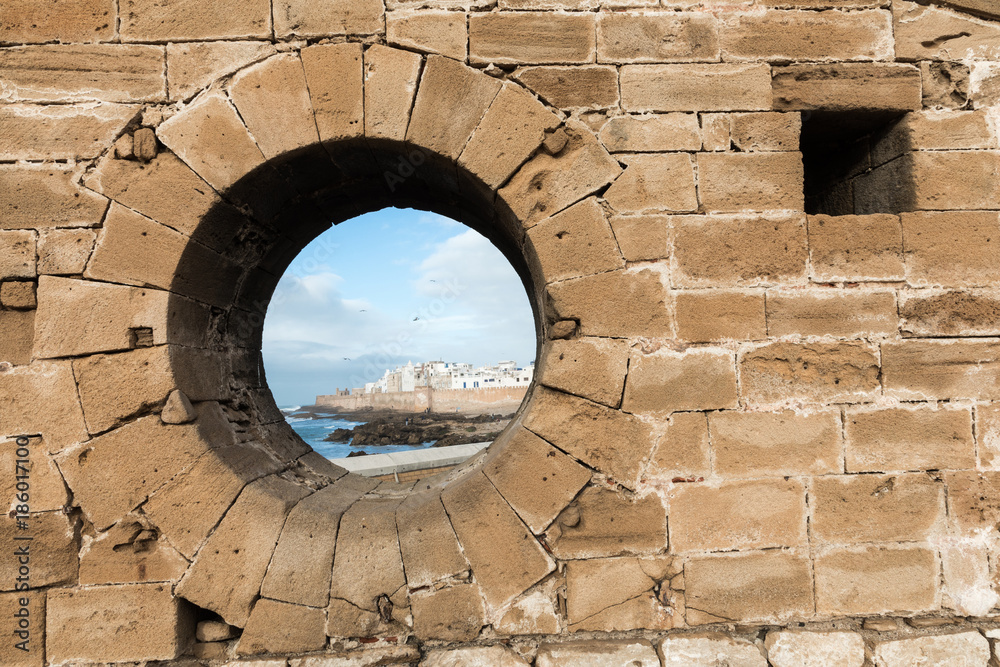 Classic view of medina Essaouira through a hole in the wall of the fortress, Morocco. UNESCO world heritage site