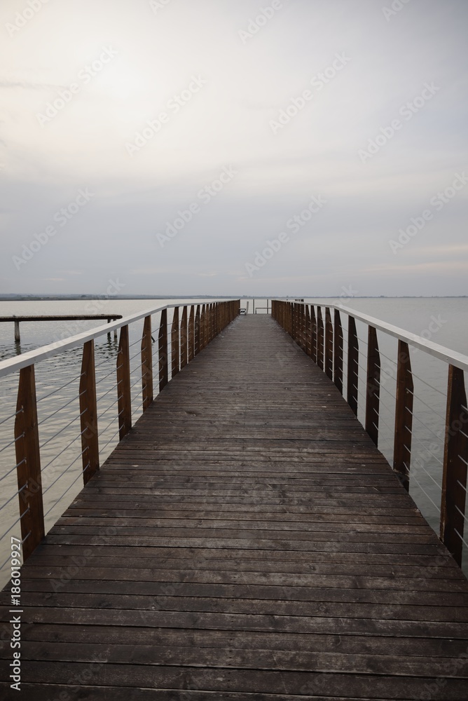 Wooden walk on Lesina lake in a cloudy and foggy day (backdrop)