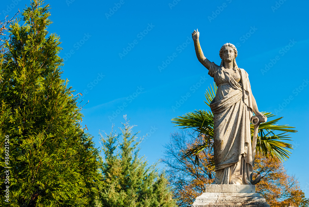 Fototapeta premium The sculpture of a woman with the anchor of hope on the Oakland Cemetery in sunny autumn day, Atlanta, USA 