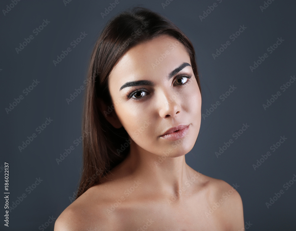 Beautiful young woman with eyelash extensions on grey background Beautiful young woman with eyelash extensions on grey background