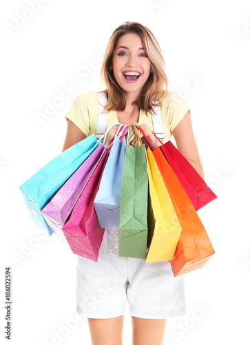 Excited young woman with shopping bags on white background