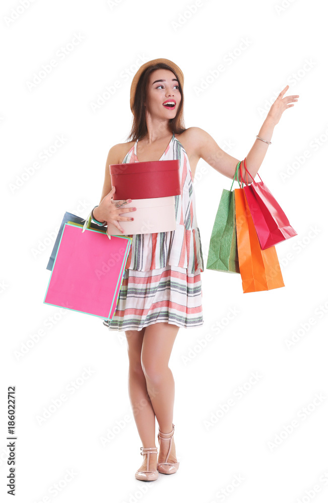 Happy young woman with shopping bags and boxes on white background