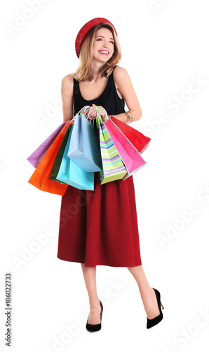 Happy young woman with shopping bags on white background
