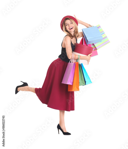 Happy young woman with shopping bags and boxes on white background