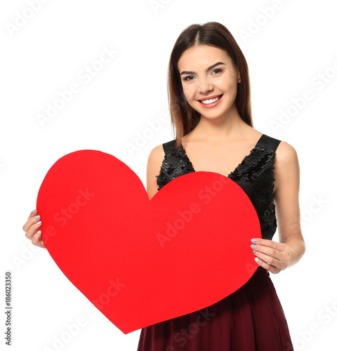 Romantic young woman with paper heart for Valentine's Day on white background