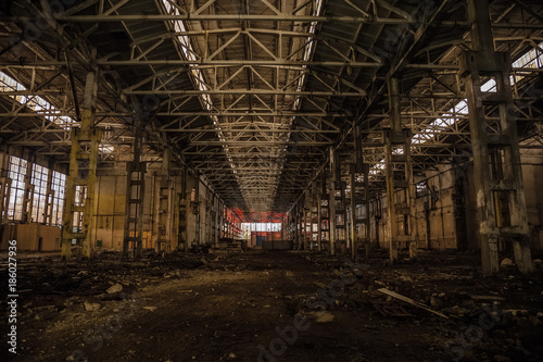 Night at large abandoned industrial hall with garbage. Voronezh excavator manufacturing factory