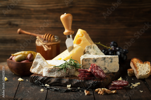 Photography Assorted cheeses with grapes, nuts and rosemary