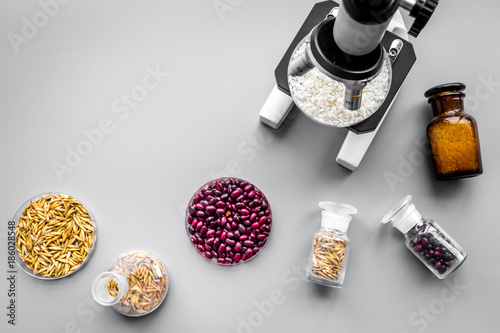 Food analysis process. Rice under microscope, red beans and wheat in petri dishes on grey background top view copyspace