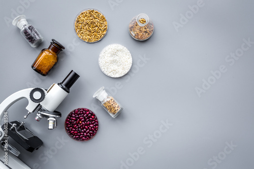 Food safety. Wheat, rice and red beans near microscope on grey background top view copyspace