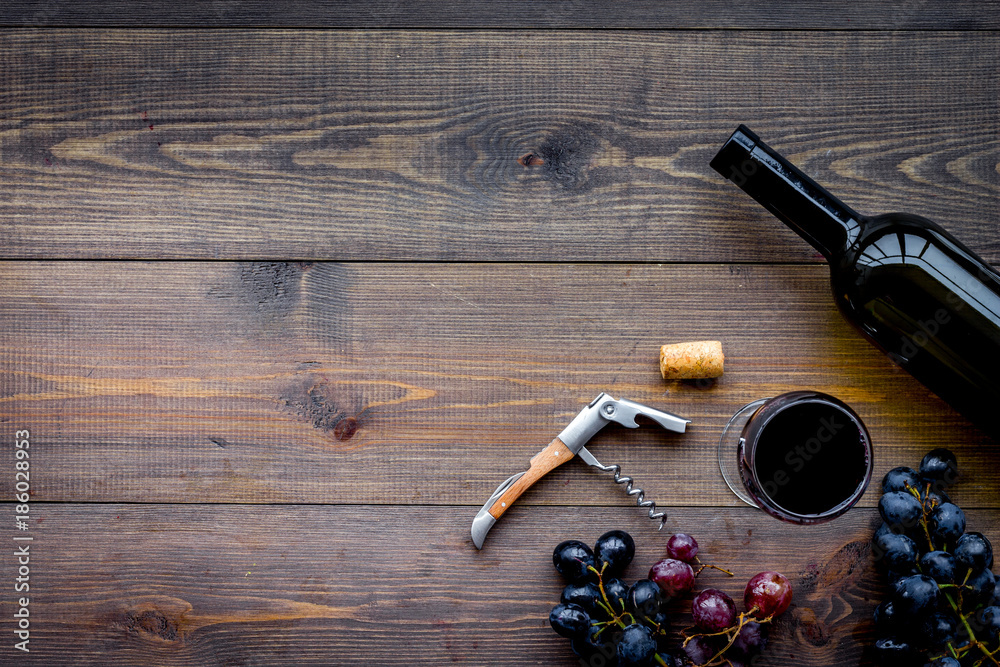 Open the wine. Corkscrew near bottle, glass, grape on wooden background top view copyspace