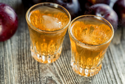 Plum brandy or slivovitz with fresh and tasty plum photo