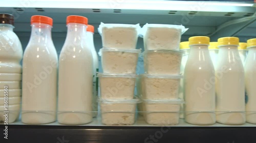 Sour-milk products in the supermarket.
Horizontal pan.
The camera moves along the shelf on which there are cottage cheese, milk, kefir and yogurt.