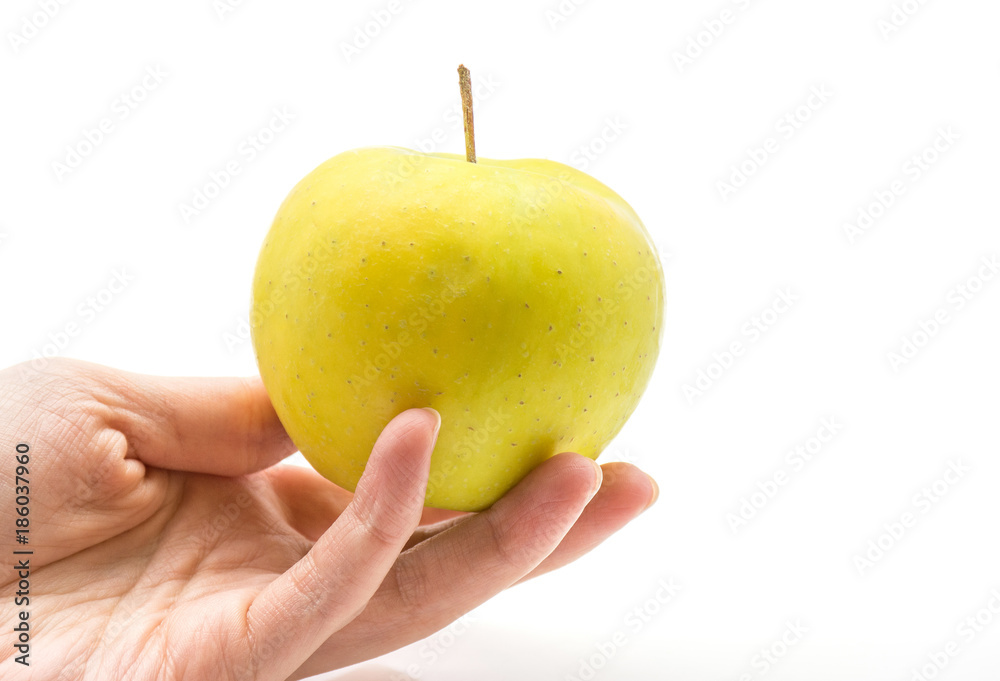 Apple (Smeralda variety) in a hand isolated on white background green yellow. Apple (Smeralda variety) in a hand isolated on white background green yellow.