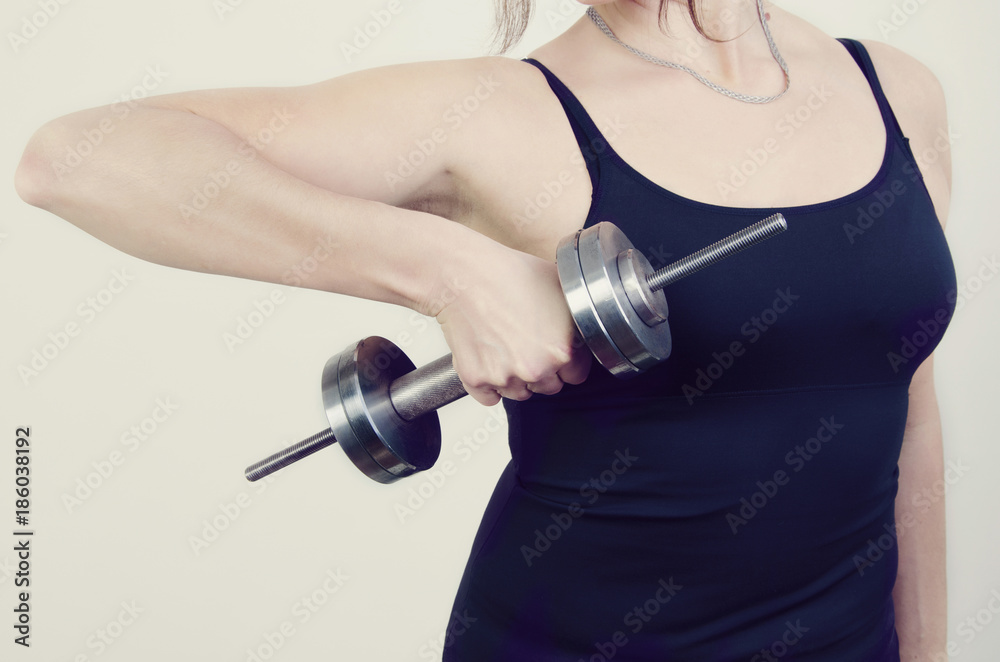the girl is holding a dumbbell in her hand the girl is holding a dumbbell in her hand