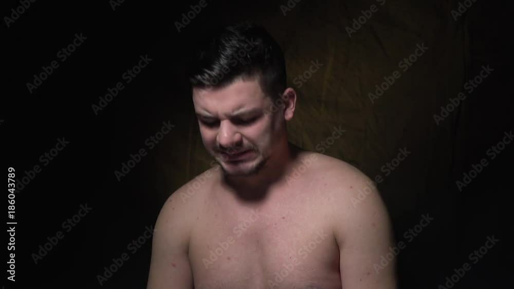A sad bearded man is standing topless A sad bearded man is standing topless