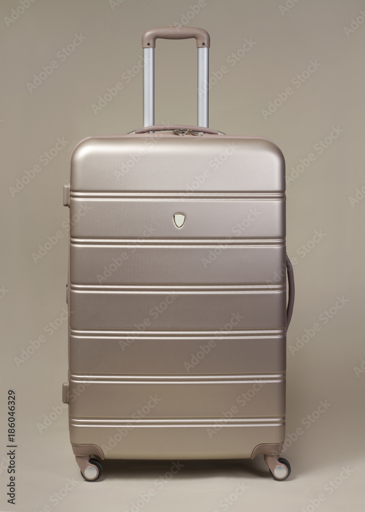 Large golden trolley suitcase isolated Large golden trolley suitcase isolated