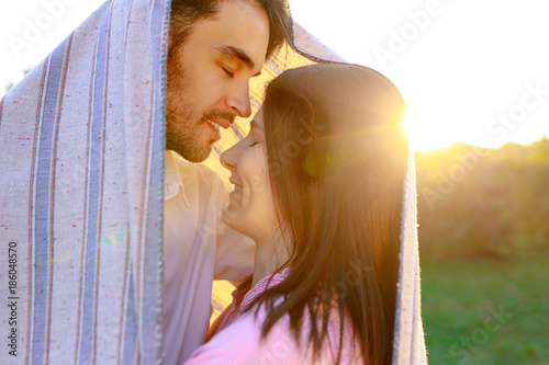 Happy couple portrait wrapped in a blanket  photo