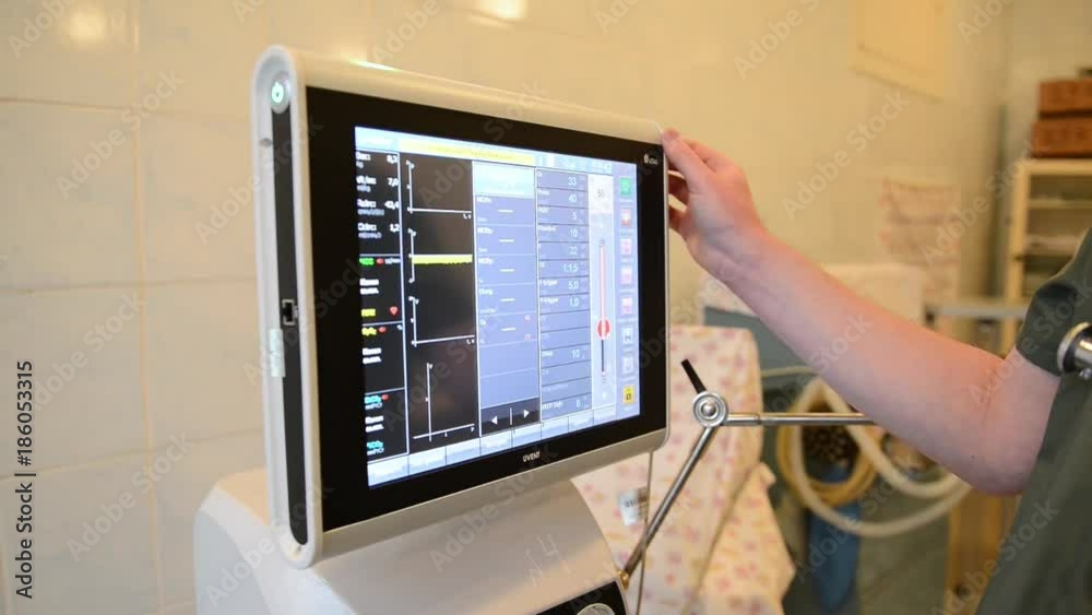 doctor man adjusts medical device with monitor doctor man adjusts medical device with monitor