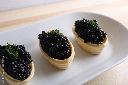 black caviar tartlet wooden background