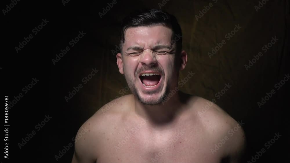 The dark-haired man closes his eyes and screams, slow motion The dark-haired man closes his eyes and screams, slow motion