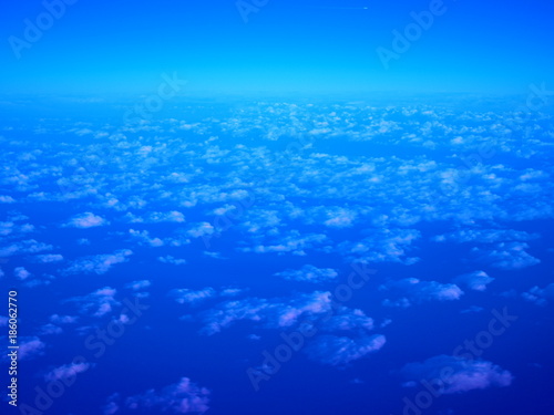 Deep dark blue early morning sky with very small white scattering, distributed fine carpet like clouds pattern, diagonal lines blending to horizon skyline above, and small clear area above background