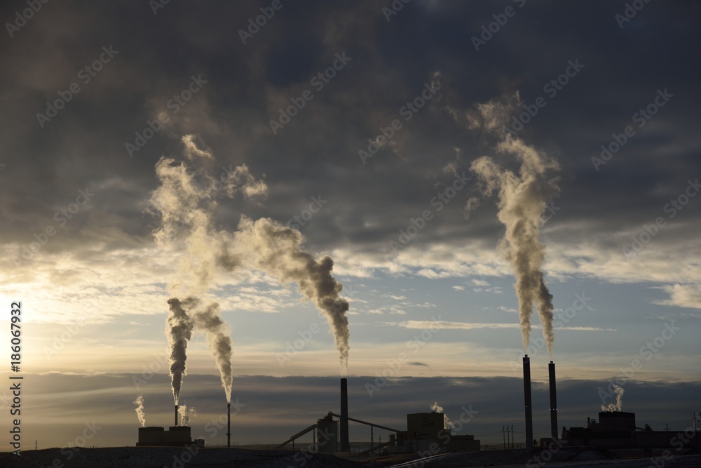 Sunset silhouette of smokestack carbon emission plumes at a coal fired power plant in Wyoming