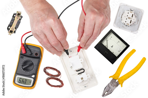 An professional technican  electrican  checks the isolation of the light switch using a multimeter photo