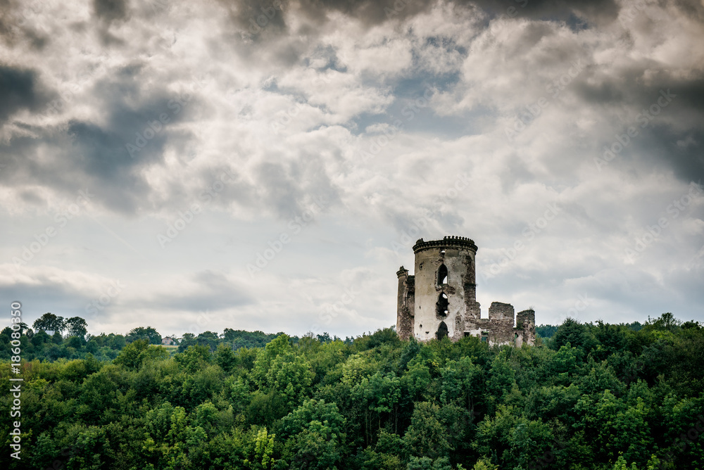 two towers of the old castle. Ruins of the palace side. Chervonogradsky Castle, Ukraine. Clouds in the sky.
