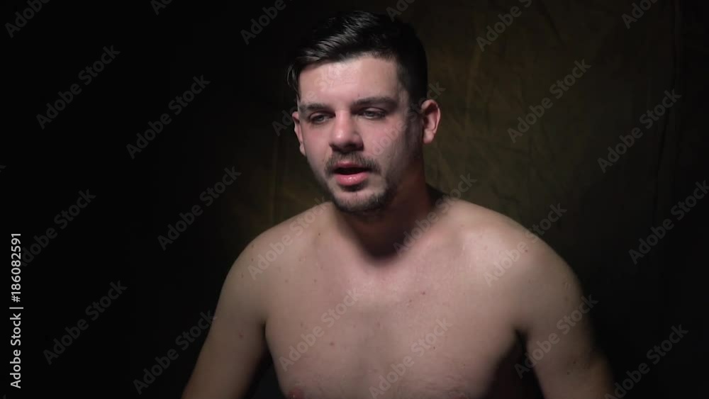 Dark-haired man is topless and sneezes Dark-haired man is topless and sneezes