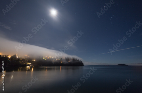 Fog covering the land on a starry night with moon lit © Bun