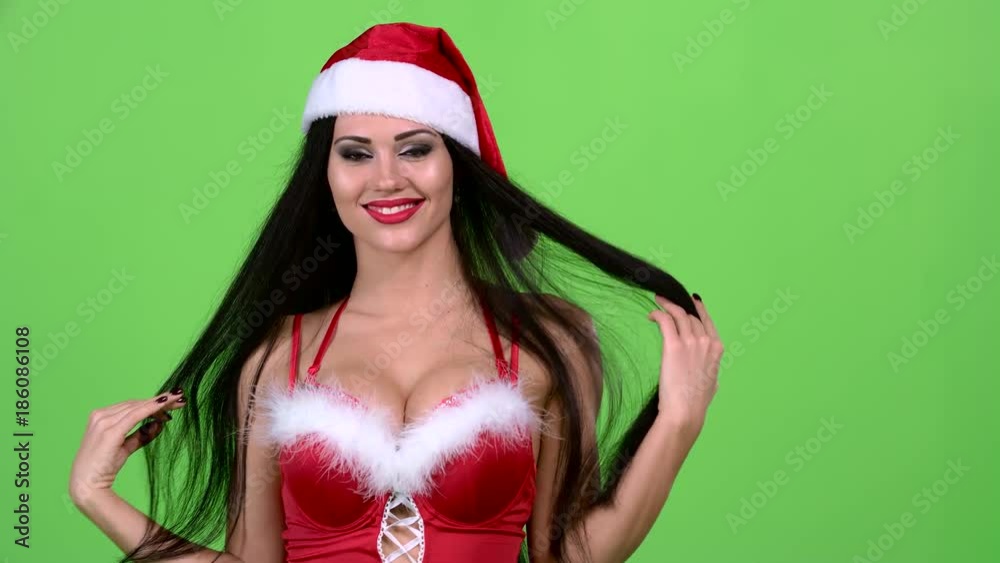 Santa woman in a sexy suit is walking down the road and smiling. Green screen. Slow motion. Slow motion