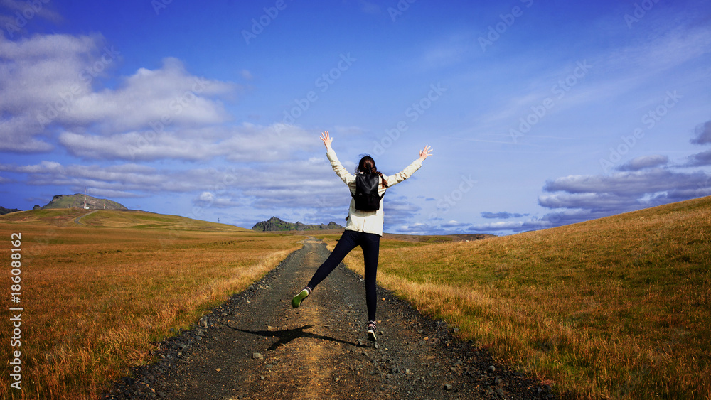 Woman tourist with backpack on the background road. Toward the goal Woman tourist with backpack on the background road. Toward the goal