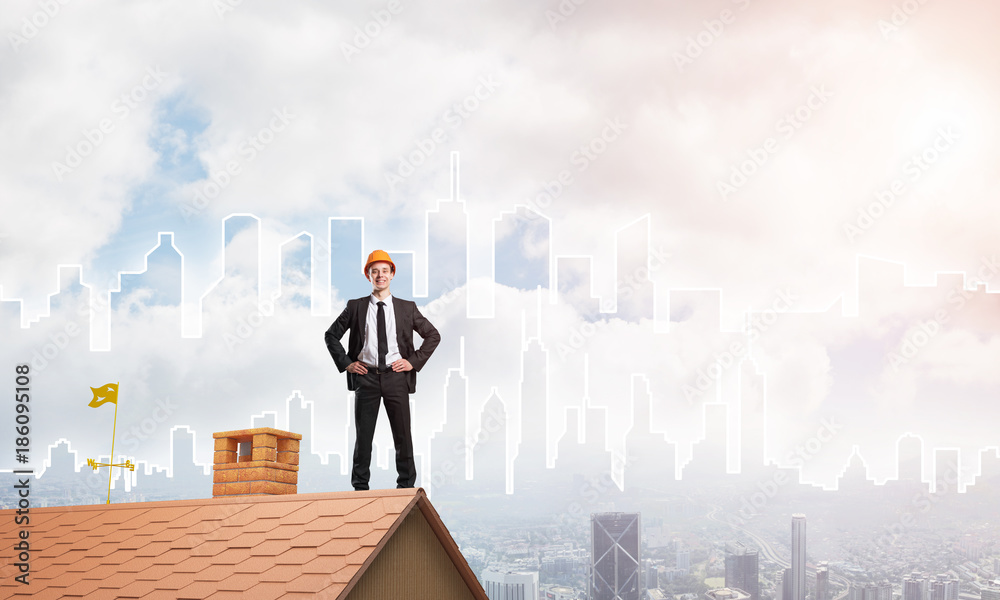 Engineer man standing on roof and looking away. Mixed media