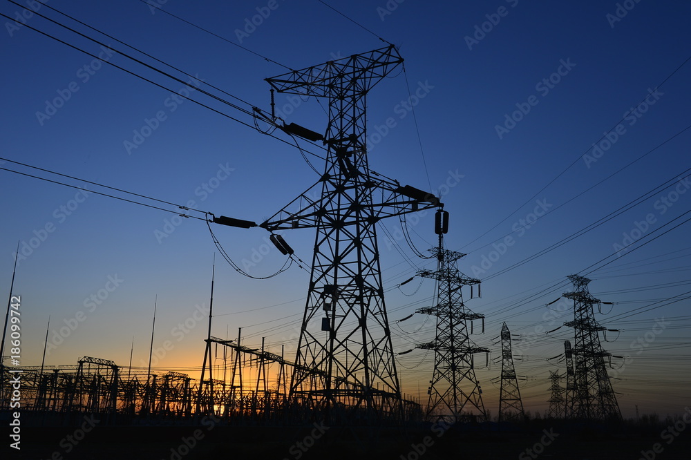 Fototapeta premium The silhouette of the evening electricity transmission pylon