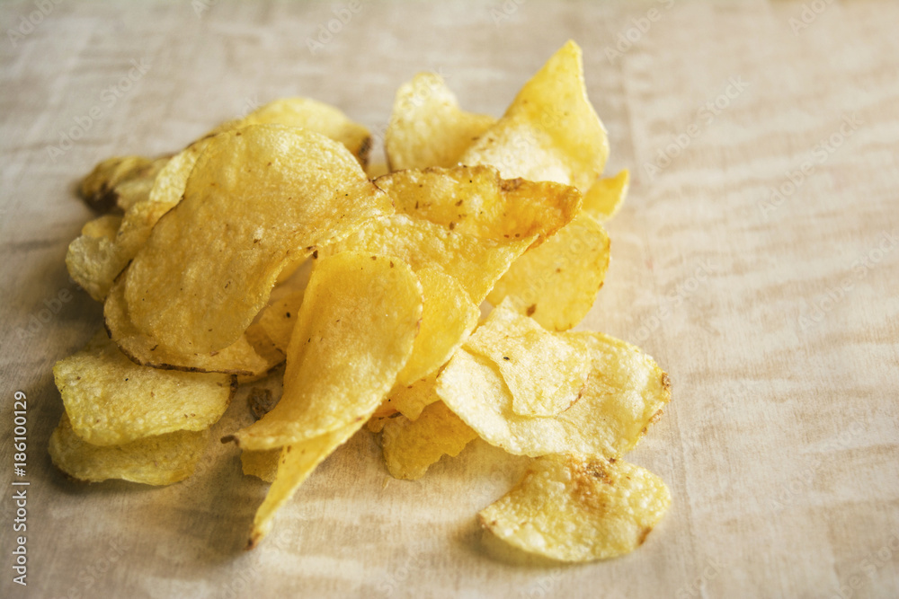 Salted potato chips on wooden background