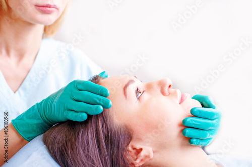 Cosmetic surgeon examining female client in clinik before plastic surgery Rhinoplasty